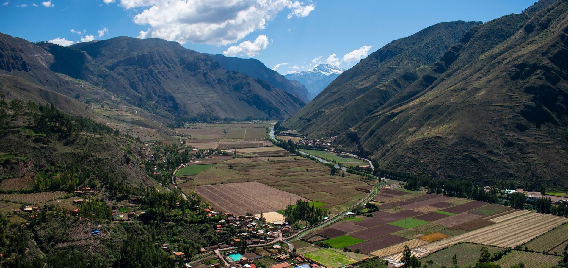 Valle andino del Perú con comunidad, chacras y nevado al fondo